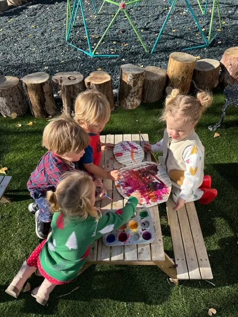 Children painting together during an outdoor art activity